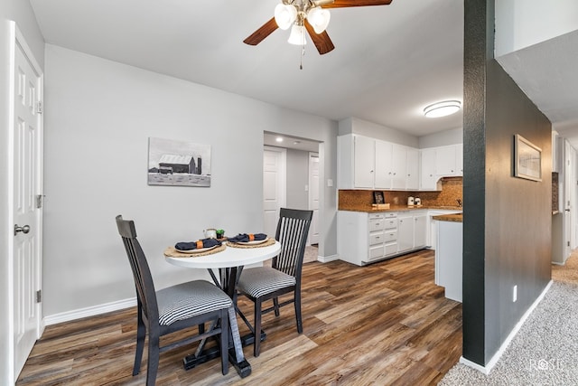 dining area featuring dark wood finished floors, baseboards, and a ceiling fan