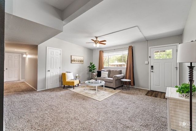 living area featuring baseboards, ceiling fan, and carpet flooring