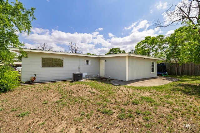 rear view of house with fence, a yard, central air condition unit, and a patio