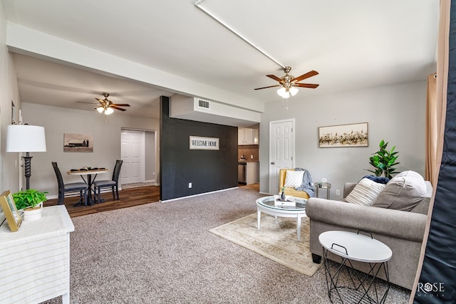 living area with baseboards, a ceiling fan, and carpet flooring