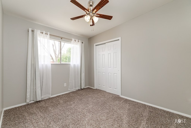 unfurnished bedroom with a closet, carpet flooring, a ceiling fan, and baseboards