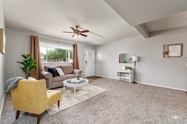 carpeted living room with attic access, a ceiling fan, and baseboards