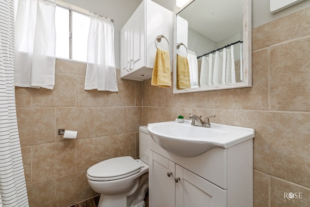 full bathroom featuring toilet, curtained shower, tile walls, and vanity