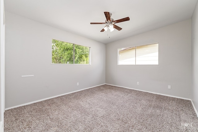 empty room featuring baseboards, a ceiling fan, carpet flooring, and plenty of natural light