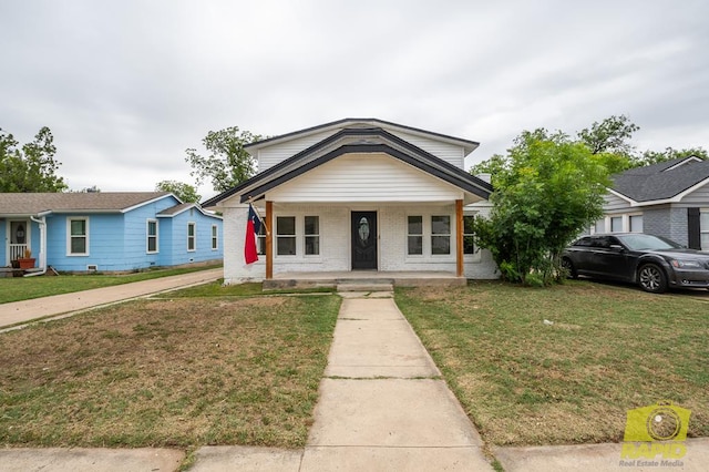 bungalow-style home featuring a front yard, a porch, and brick siding