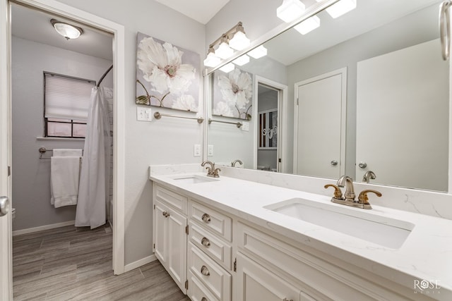 3110 Palo Duro Dr, San Angelo, TX 76904 - full bathroom with double vanity, wood finished floors, and a shower with curtain
