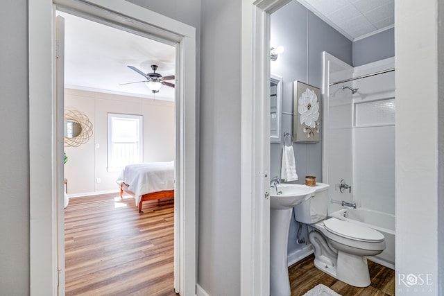 34 W 9th St, San Angelo, TX 76903 - full bath featuring crown molding, wood finished floors, toilet, a ceiling fan, and bathtub / shower combination