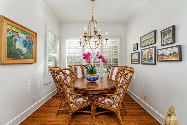 dining area featuring baseboards, wood finished floors, a chandelier, and crown molding