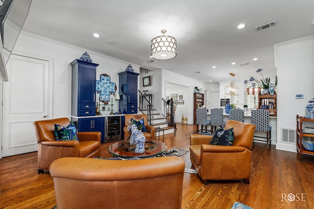 living room featuring visible vents, crown molding, stairs, and wood finished floors