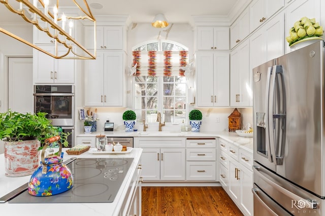 kitchen with white cabinets, stainless steel appliances, dark wood-type flooring, and a sink