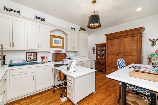 office space with recessed lighting, wood finished floors, and built in desk