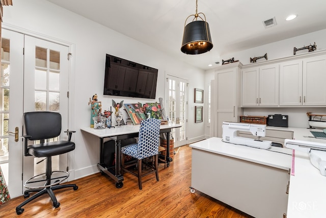 kitchen with visible vents, light countertops, light wood-style floors, white cabinetry, and decorative light fixtures