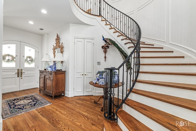 foyer entrance with recessed lighting, french doors, wood finished floors, and stairway