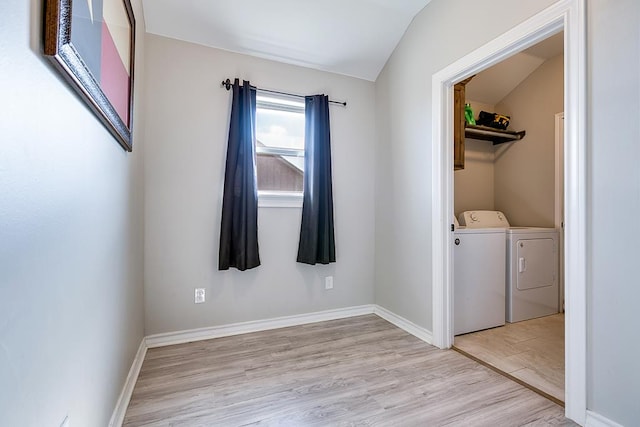 washroom featuring washing machine and clothes dryer and light hardwood / wood-style flooring