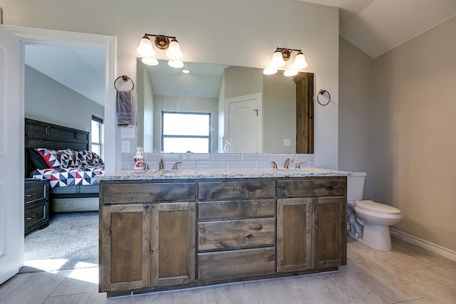 bathroom featuring vanity, lofted ceiling, and toilet