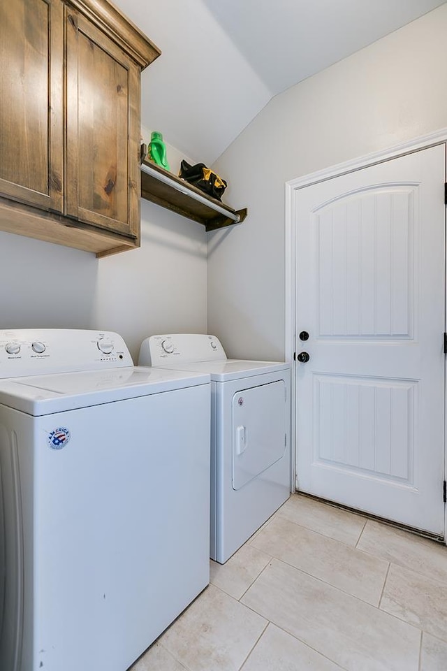 laundry room featuring cabinets, light tile patterned floors, and independent washer and dryer