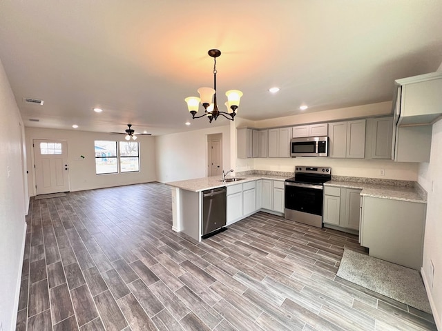 kitchen featuring wood finish floors, visible vents, gray cabinets, open floor plan, and appliances with stainless steel finishes