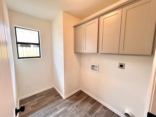 laundry room featuring baseboards, wood finish floors, hookup for a washing machine, cabinet space, and hookup for an electric dryer