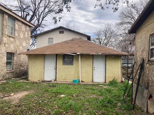 back of property featuring an outbuilding and a lawn