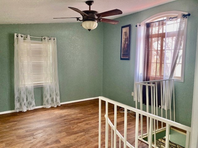 unfurnished room featuring hardwood / wood-style floors and ceiling fan