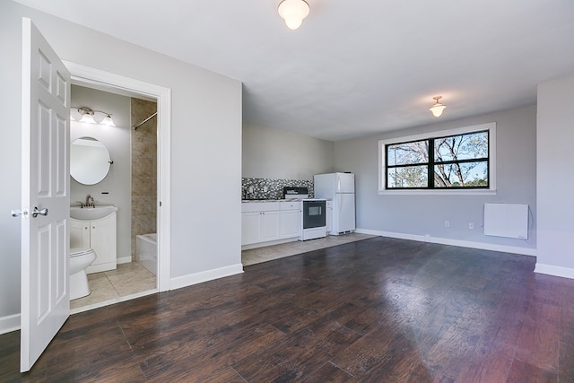 unfurnished living room with sink and hardwood / wood-style floors