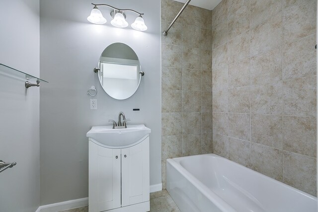 bathroom featuring tiled shower / bath combo, vanity, and tile patterned floors