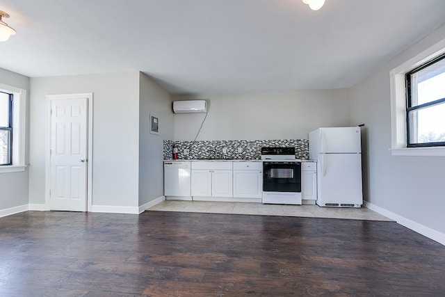 kitchen featuring an AC wall unit, sink, white cabinets, backsplash, and white appliances