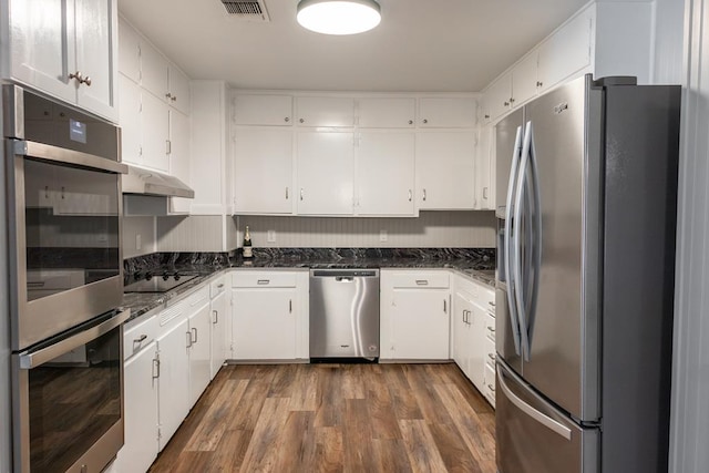 kitchen featuring under cabinet range hood, appliances with stainless steel finishes, white cabinetry, and dark wood-type flooring