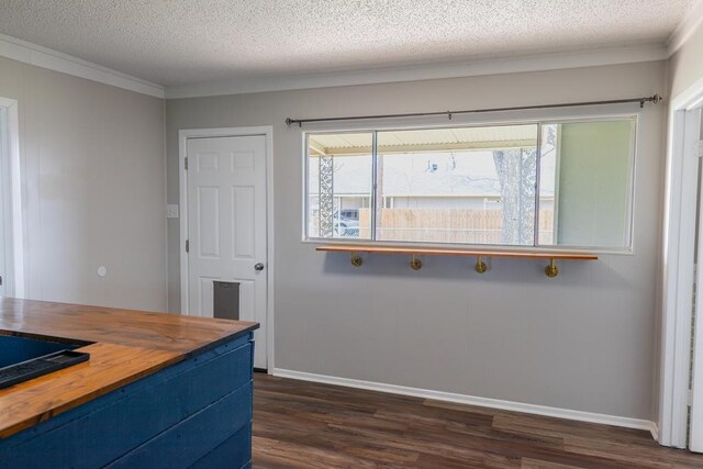 interior space featuring wooden counters, a textured ceiling, crown molding, baseboards, and dark wood-style flooring