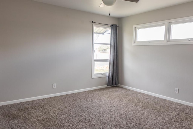 carpeted spare room with baseboards and ceiling fan