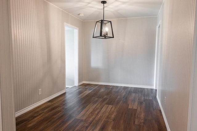 unfurnished dining area with baseboards, dark wood-type flooring, and an inviting chandelier