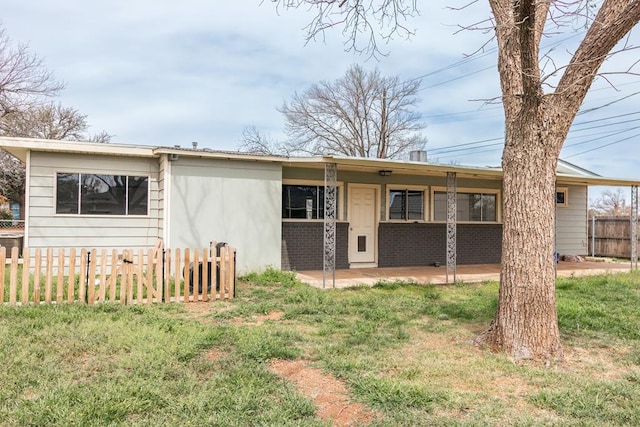 back of house featuring brick siding, a patio, and fence