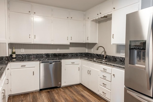 kitchen with dark wood finished floors, appliances with stainless steel finishes, white cabinetry, and a sink