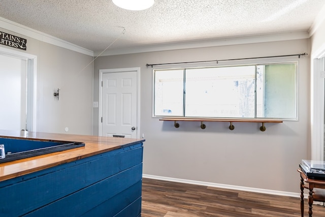 interior space with hardwood / wood-style flooring, ornamental molding, and a textured ceiling