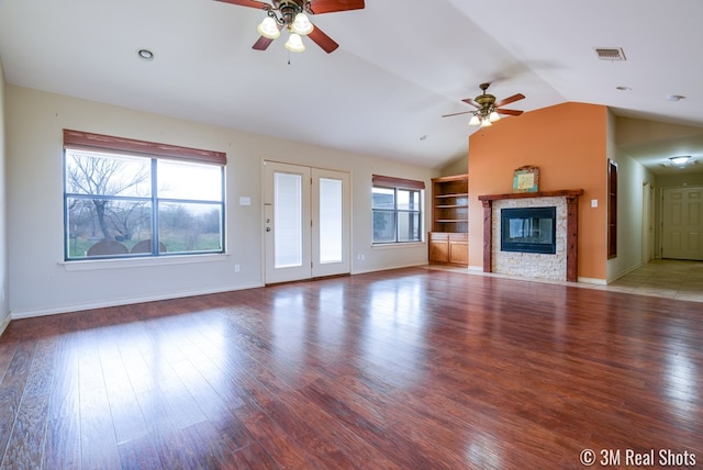 unfurnished living room with a glass covered fireplace, plenty of natural light, and light wood finished floors