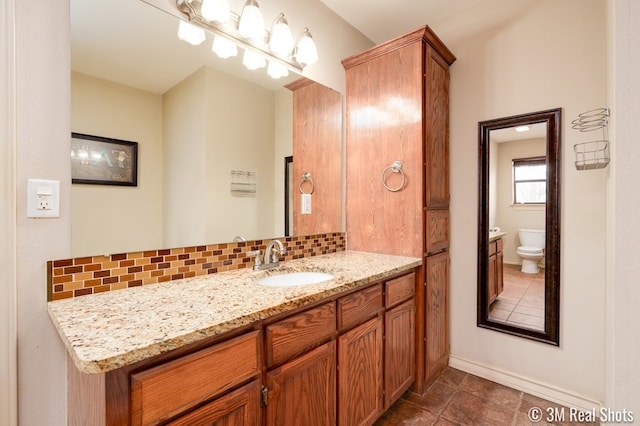 bathroom with tasteful backsplash, vanity, and toilet