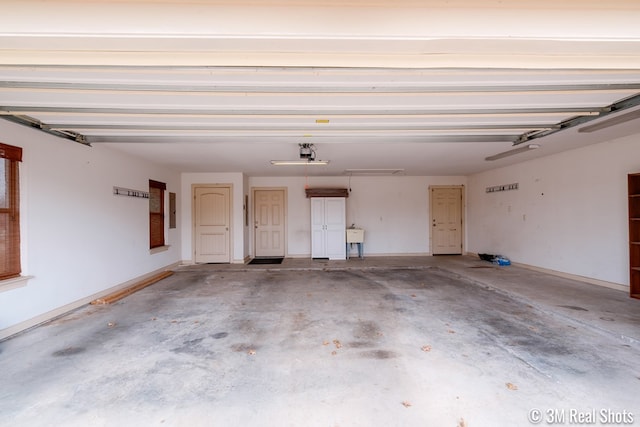 garage featuring electric panel and baseboards