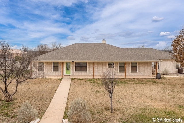 back of property with roof with shingles, brick siding, a chimney, and a patio