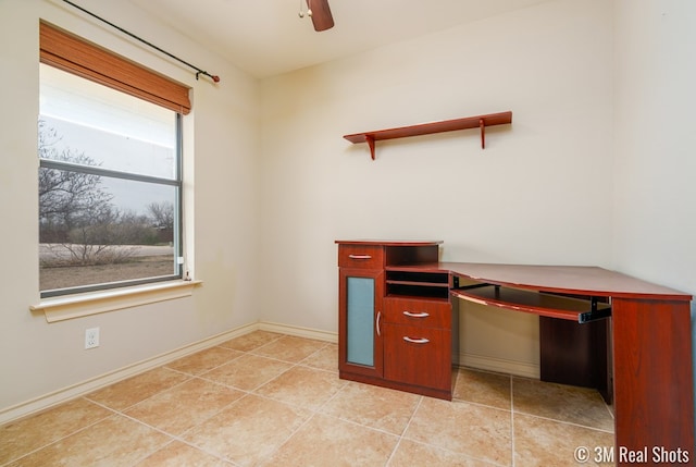 unfurnished office with light tile patterned flooring, a ceiling fan, and baseboards