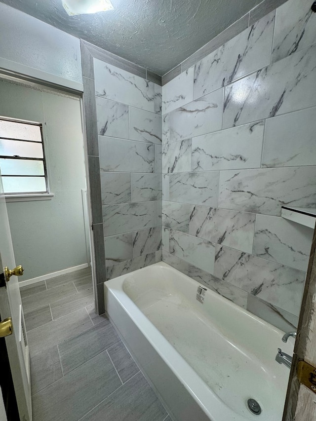 1025 Linda Lee Dr, San Angelo, TX 76905 - full bathroom featuring a textured ceiling, shower / bathtub combination, and baseboards