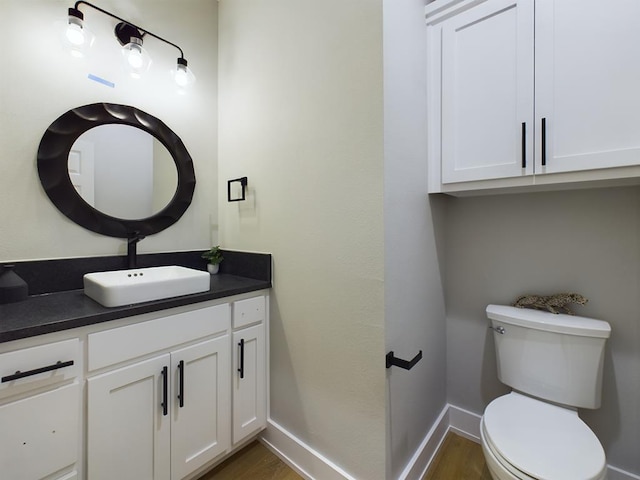 bathroom featuring vanity, hardwood / wood-style flooring, and toilet