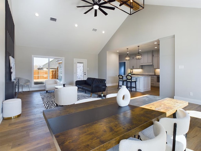 dining space with ceiling fan, dark hardwood / wood-style floors, and high vaulted ceiling