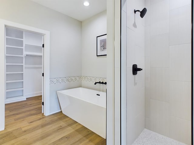 bathroom featuring hardwood / wood-style flooring and plus walk in shower