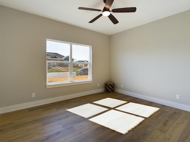 empty room with dark hardwood / wood-style floors and ceiling fan