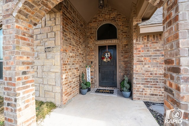 entrance to property featuring brick siding