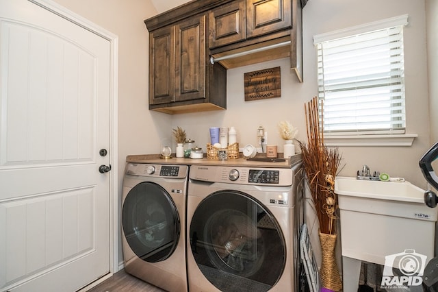 laundry room featuring a sink, washer and dryer, and cabinet space