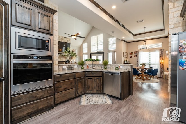 kitchen with a sink, visible vents, stainless steel appliances, dark brown cabinetry, and ornamental molding