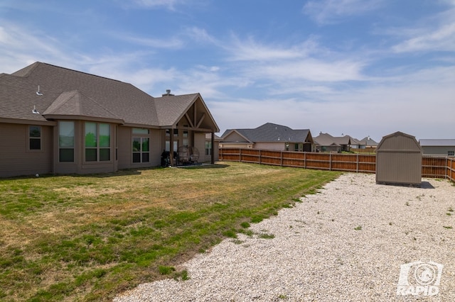 view of yard featuring an outdoor structure, a shed, and a fenced backyard