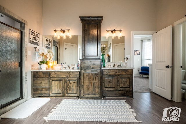 full bath with toilet, vanity, and wood finished floors
