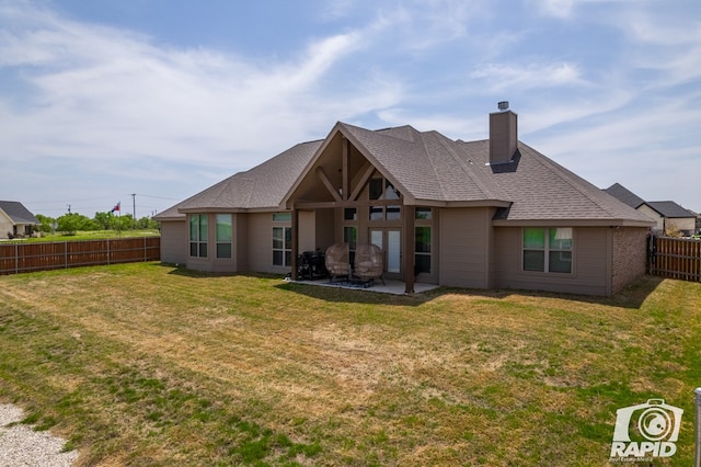 back of house with a yard, a patio area, a fenced backyard, and a chimney